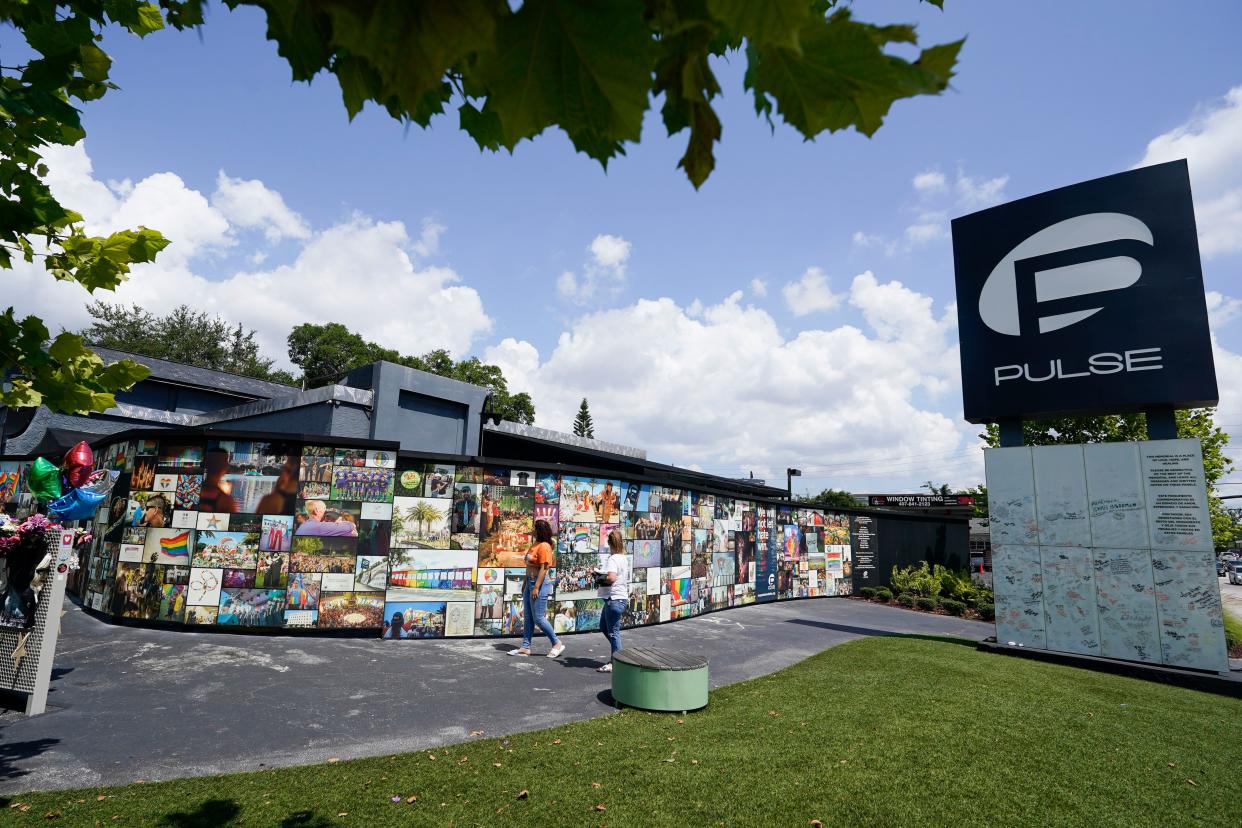 Visitors pay tribute to the display outside the Pulse nightclub memorial Friday, June 11, 2021, in Orlando, Fla. Saturday will mark the fifth anniversary of the mass shooting at the site. (AP Photo/John Raoux)