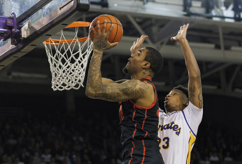 Houston's Reggie Chaney, left, shoots next to East Carolina's Brandon Johnson (23) during the first half of an NCAA college basketball game in Greenville, N.C., Saturday, Feb. 25, 2023. (AP Photo/Ben McKeown)