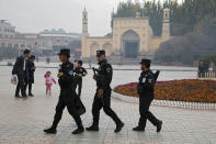 FILE - In this Nov. 4, 2017, file photo, Uighur security personnel patrol near the Id Kah Mosque in Kashgar in western China's Xinjiang region. A database obtained by The Associated Press offers the fullest and most personal view yet into how Chinese officials decided who to put into and let out of detention camps, as part of a massive crackdown that has locked away more than a million ethnic minorities, most of them Muslim. (AP Photo/Ng Han Guan, File)