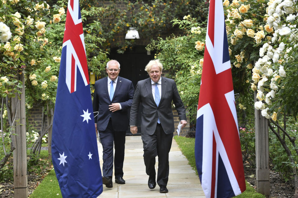 Britain's Prime Minister Boris Johnson, right, walkswith Australian Prime Minister Scott Morrison after their meeting, in the garden of 10 Downing Streeet, in London, Tuesday June 15, 2021. Britain and Australia have agreed on a free trade deal that will be released later Tuesday, Australian Trade Minister Dan Tehan said. (Dominic Lipinski/Pool Photo via AP)
