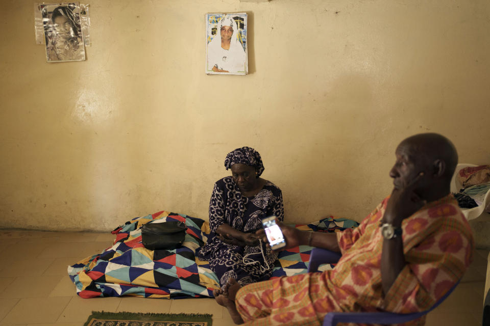 Seynabou Diop looks on as she sits next to her husband while he holds a mobile phone with a picture of their son, Khadim Ba, 21, who died during the protests earlier this month in Dakar, Senegal, Thursday, June 15, 2023. "If I had known (he was going to protest), Khadim would never have taken part," said Diop. "I want (the government) to meet the expectations of young people, the government has an obligation to help (them)," she said. (AP Photo/Leo Correa)