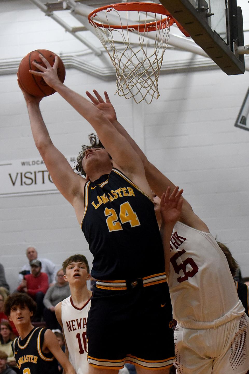 Lancaster senior Sam Finck and Newark freshman Austin Rose fight for an rebound during the Wildcats' 51-29 OCC-Buckeye win Friday night.