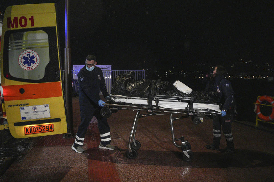 Paramedics carry the body of a crew member of a ship, on the northeastern Aegean Sea island of Lesbos, Greece, Sunday, Nov. 26, 2023. A cargo ship sank off the Greek island of Lesbos early Sunday, leaving 13 crew members missing and one rescued, authorities said. The Raptor, registered in the Comoros, was on its way to Istanbul from Alexandria, Egypt, carrying 6,000 tons of salt, the coast guard said. It had a crew of 14, including eight Egyptians, four Indians and two Syrians, the coast guard said.(AP Photo/Panagiotis Balaskas)