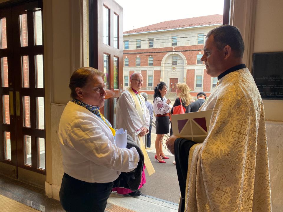 Father Myron Myronyk of Saint Vladimir Ukrainian Catholic Church of Scranton speaks with a member of the choir following the prayer service on Sunday.