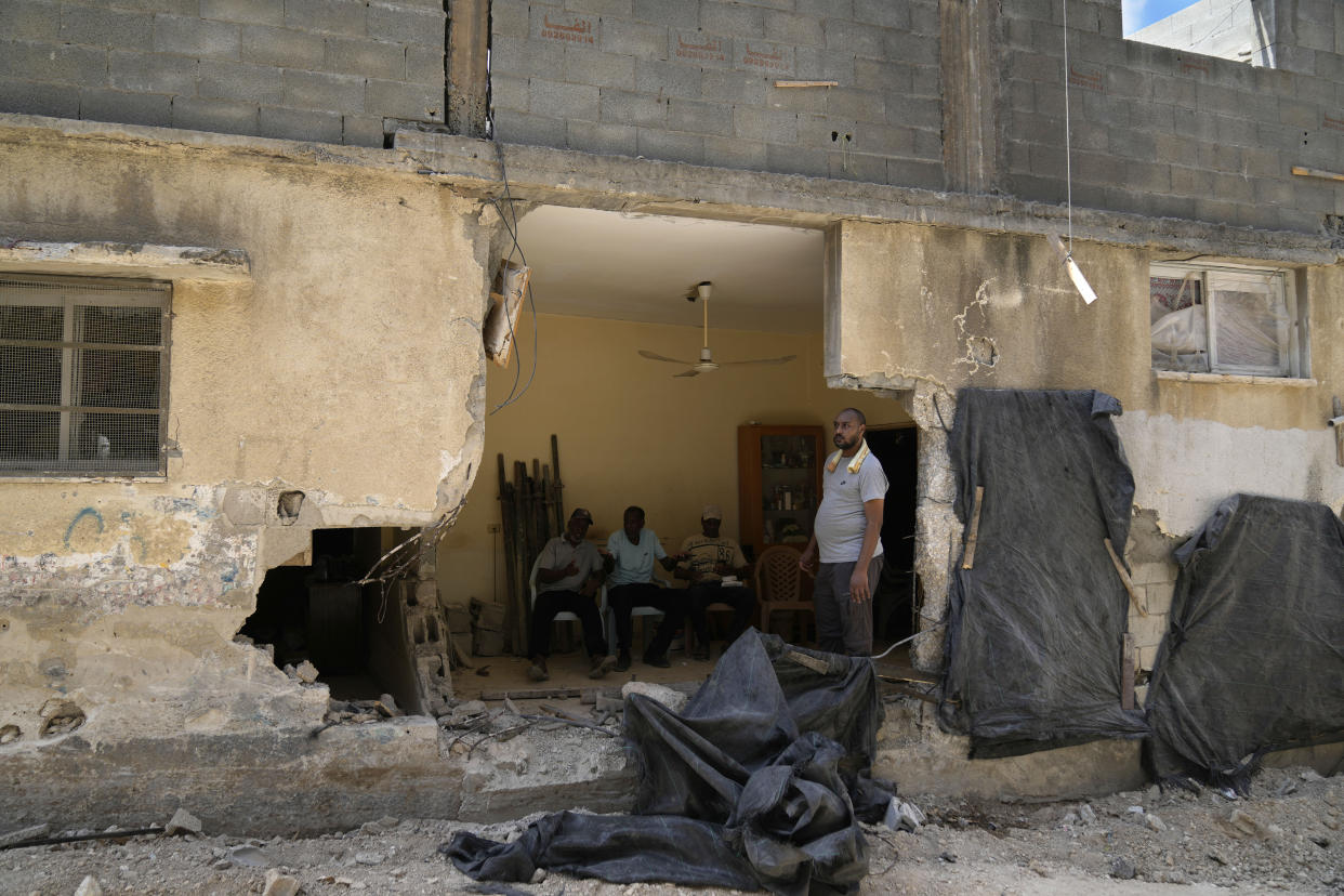 Palestinian refugees sit inside their partly destroyed house that was damaged during the Israeli army operation in the West Bank refugee camp of Tulkarem, in Tulkarem, Thursday, Sept. 5, 2024. (AP Photo/Nasser Nasser)