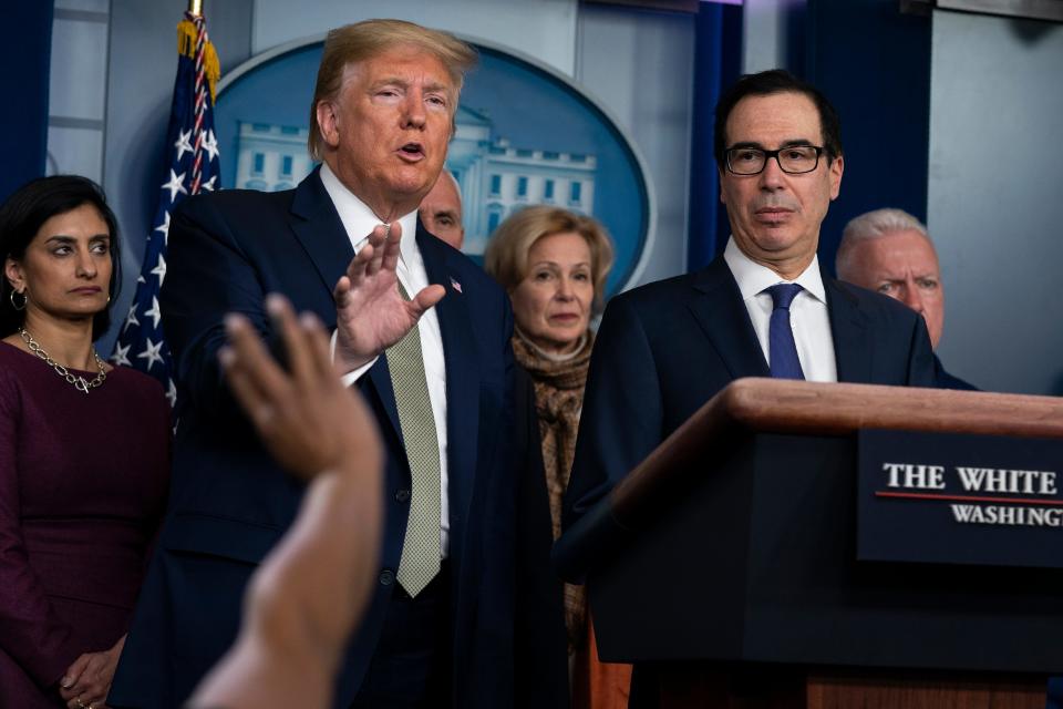 Treasury Secretary Steven Mnuchin, right, listens as President Donald Trump speaks during a press briefing with the coronavirus task force, at the White House, Tuesday, March 17, 2020.