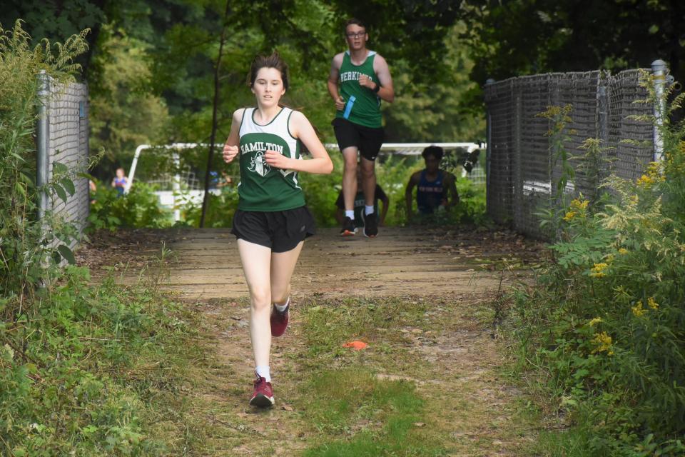 Hamilton Emerald Knight Clare Roller crosses a foot bridge on Poland's cross country course on her way to a win at Wednesday's five-team dual meet.