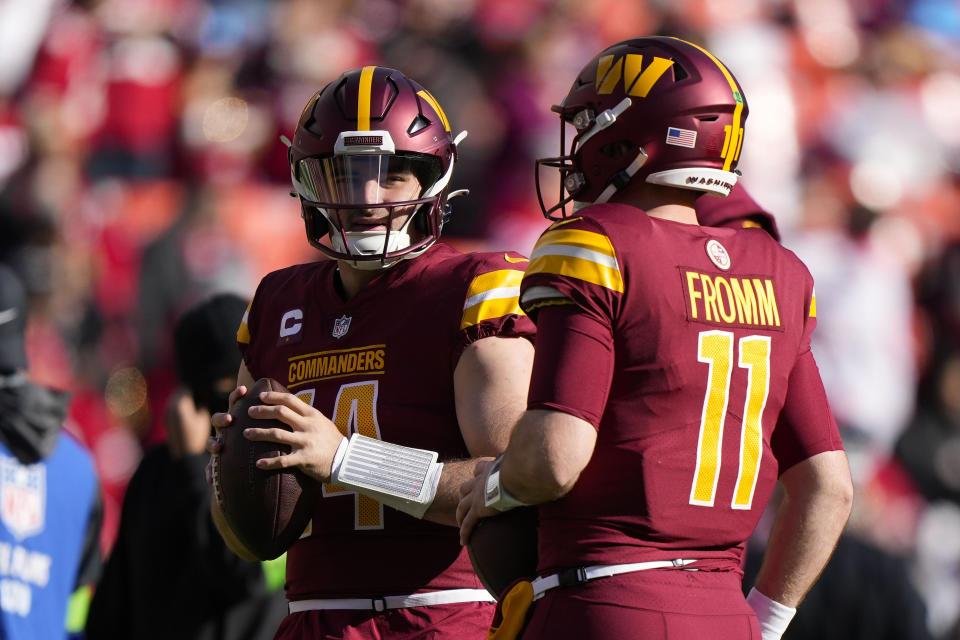 Washington Commanders quarterbacks Sam Howell (14) and Jake Fromm (11) talking during pregame warmups before the start of the first half of an NFL football game, Sunday, Dec. 31, 2023, in Landover, Md. (AP Photo/Mark Schiefelbein)