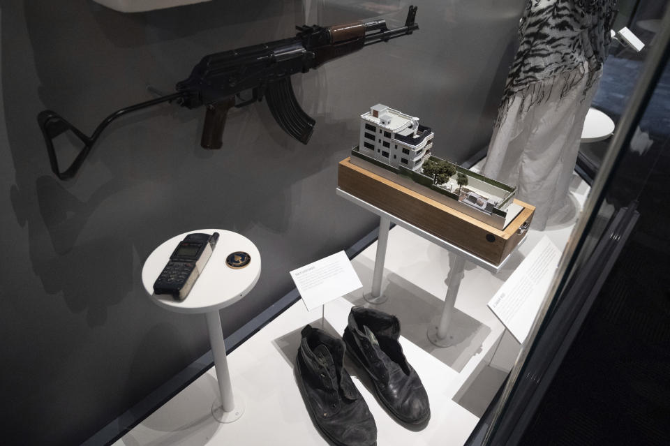 A model of the house where a precision counterterrorism operation killed al-Qaida's leader Ayman al-Zawahri is displayed below a rifle used by Michael Spann, the first American killed in Afghanistan, in the refurbished museum at the Central Intelligence Agency headquarters building in Langley, Va., Saturday, Sept. 24, 2022. (AP Photo/Kevin Wolf)