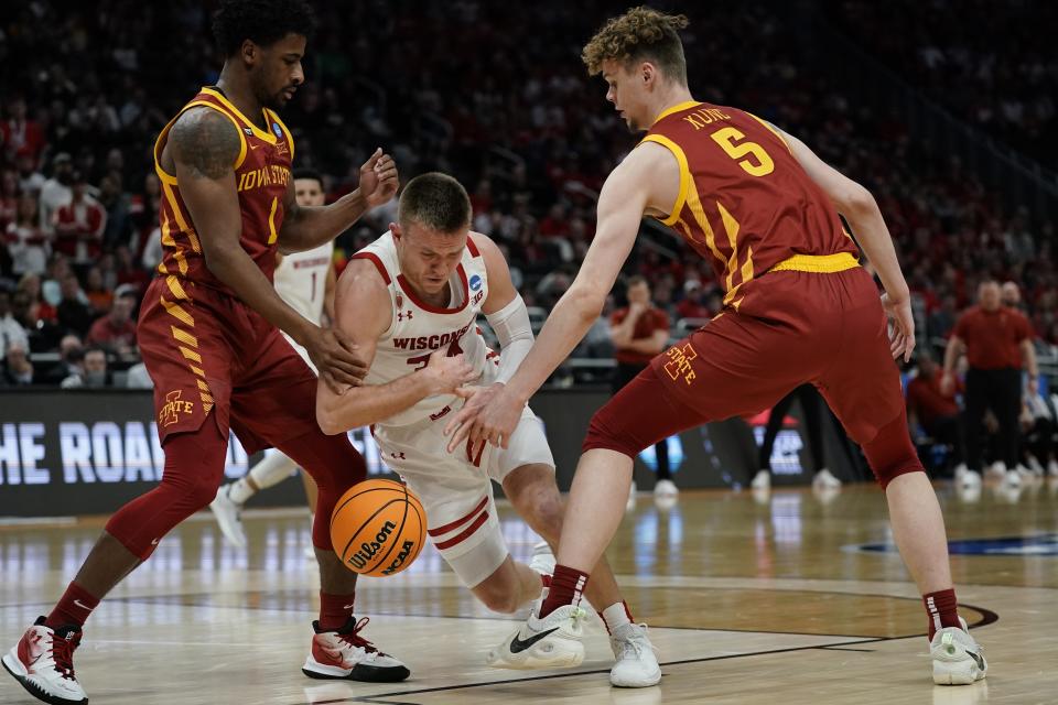 Wisconsin's Brad Davison loses the ball as he drives between Iowa State's Izaiah Brockington and Aljaz Kunc during the second half of a second-round NCAA college basketball tournament game Sunday, March 20, 2022, in Milwaukee. (AP Photo/Morry Gash)