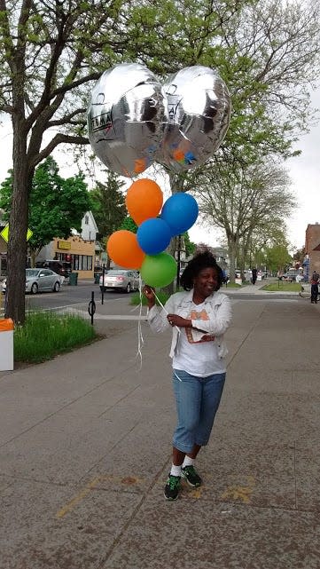 Charlotte Burch, a small-business owner and president of the Thurston Brooks Merchant Association, distributes balloons to businesses participating in Ease on Down.