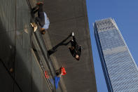 People are reflected on panels of the French luxury brand Louis Vuitton flagship store at the Central Business District in Beijing, Wednesday, March 6, 2019. China will bar government authorities from demanding overseas companies hand over technology secrets in exchange for market share, a top economic official said Wednesday, addressing a key complaint at the heart of the current China-U.S. trade dispute. (AP Photo/Andy Wong)