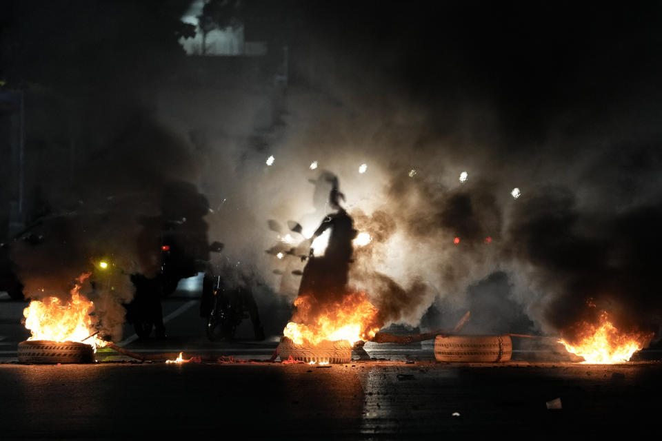 La sombra de un motociclista atraviesa una barricada en la avenida Bolívar en Caracas, Venezuela, el lunes 29 de julio de 2024, el día después de las elecciones presidenciales. (AP Foto/Matías Delacroix)