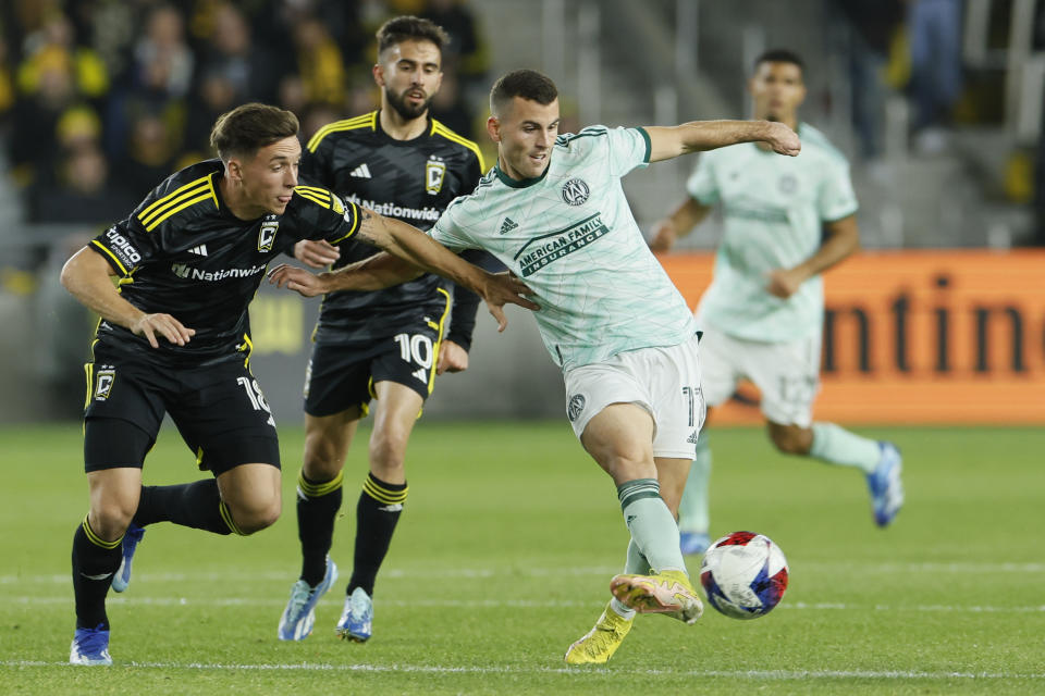 Atlanta United's Brooks Lennon, right, keeps the ball away from Columbus Crew's Malte Amundsen, left, and Diego Rossi, center, during the first half of an MLS playoff soccer match Sunday, Nov. 12, 2023, in Columbus, Ohio. (AP Photo/Jay LaPrete)