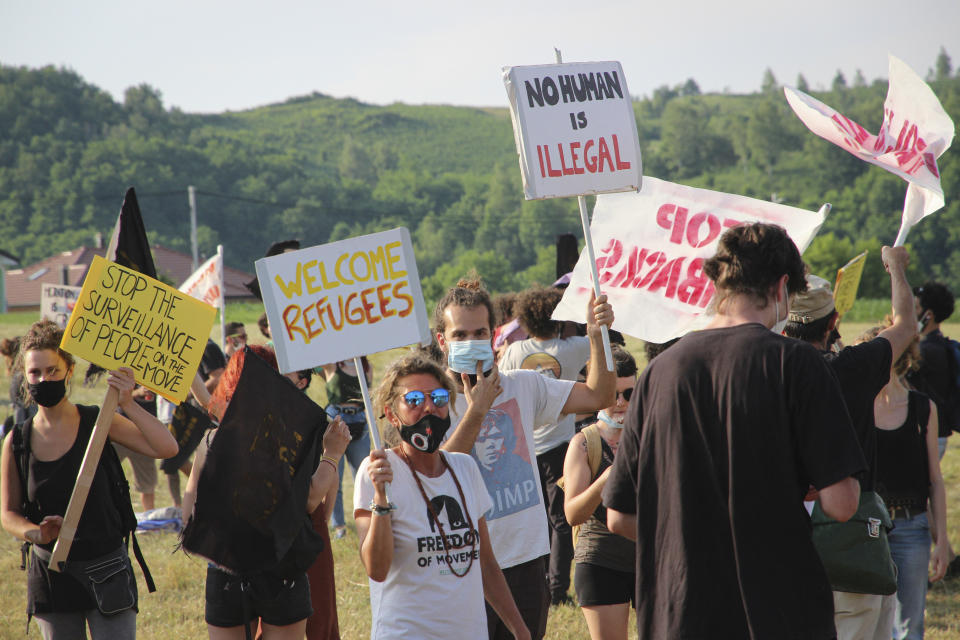 People take part in a protest against the violent pushbacks of migrants, allegedly conducted by Croatian police, near the border crossing between Croatia and Bosnia Herzegovina in Maljevac, Croatia, Saturday, June 19, 2021. More than one hundred members of human rights NGO's, mostly from Italy, but also from Germany, Austria, Spain and Slovenia blocked the border traffic for about two hours protesting demanding a stop of all deportation of migrants, and cancellation of EU's Frontex operations at borders, preventing migrants from traveling. (AP Photo/Edo Zulic)