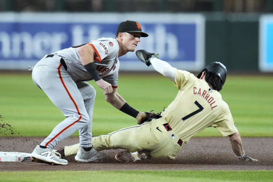 Arizona Diamondbacks' Corbin Carroll (7) steals second base as San Francisco Giants shortstop Tyler Fitzgerald applies the late tag during the first inning of a baseball game Tuesday, Sept. 24, 2024, in Phoenix. (AP Photo/Ross D. Franklin)