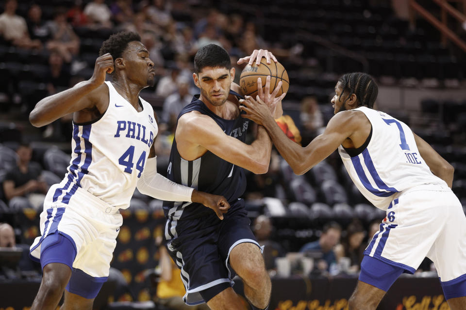 Memphis Grizzlies forward Santi Aldama (7) drives between Philadelphia 76ers forward Paul Reed Jr. (44) and guard Isaiah Joe (7) during the first quarter of an NBA summer league basketball game Tuesday, July 5, 2022, in Salt Lake City. (AP Photo/Jeff Swinger)