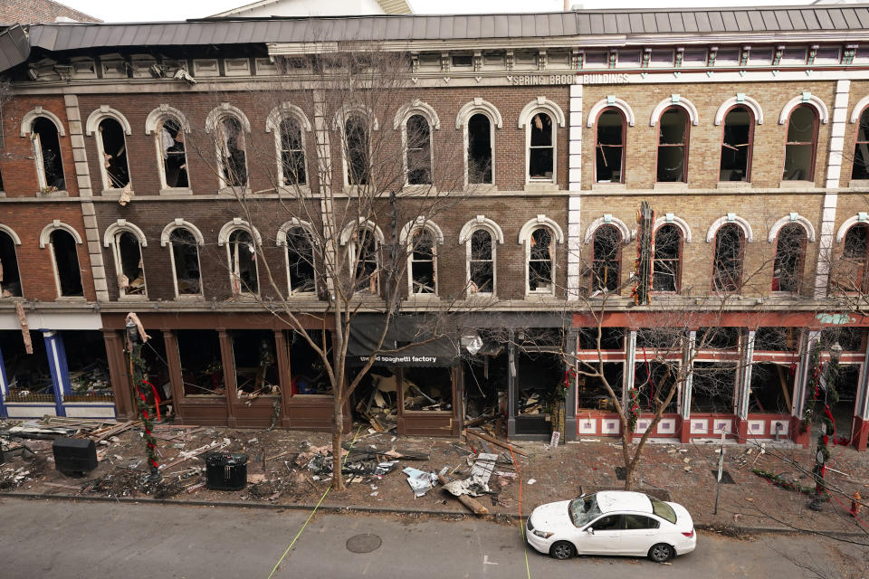 Debris remains on the sidewalks in front of buildings damaged in a Christmas Day explosion Tuesday, Dec. 29, 2020, in Nashville, Tenn. Officials have named 63-year-old Anthony Quinn Warner as the man behind the bombing in which he was killed, but the motive has remained elusive. (AP Photo/Mark Humphrey)