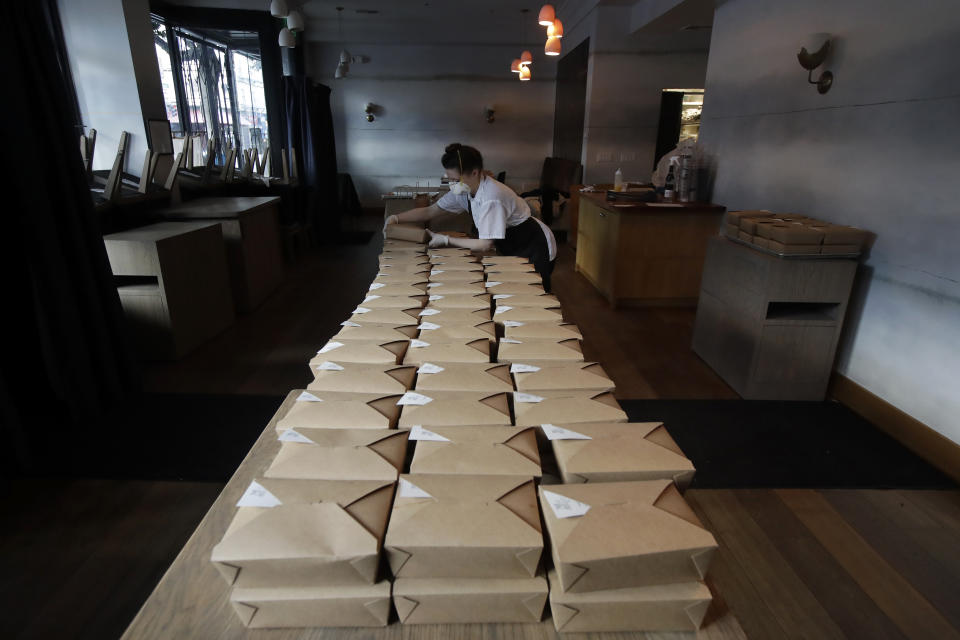 FILE - In this Friday, March 27, 2020 file photo, Nightbird Restaurant pastry chef Hope Waggoner prepares dinner boxes that were delivered to hospital workers in San Francisco. Taxpayers will pay restaurants to make three meals a day for California's millions of seniors during the coronavirus pandemic, Gov. Gavin Newsom announced Friday, April 24, 2020, putting the industry back to work and generating sales tax collections for cash-strapped local governments. California has about 5.7 million people 65 and older, but not all of them will be eligible, and some will have to meet income thresholds. (AP Photo/Jeff Chiu, File)