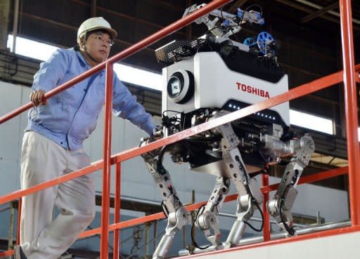 Engineers inspect Toshiba's four-legged robot during a demonstration at Toshiba's technical center in Yokohama, suburban Tokyo. The tetrapod, which weighs 65 kilograms (143 pounds) and is about one metre (3 foot, four inches) tall, is designed to be able to cover difficult terrain -- such as going up steep steps -- that regular robots struggle with