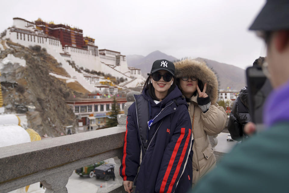 In this Feb. 9, 2019, photo released by Xinhua News Agency, tourists pose for souvenir photos in front of the Potala Palace in Lhasa, southwest China's Tibet Autonomous Region. China is barring foreign travelers from Tibet over a period of several weeks that includes a pair of sensitive political anniversaries. Travel agencies contacted Wednesday, Feb. 20 said foreign tourists would not be allowed into the Himalayan region until April 1. (Jigme Dorje/Xinhua via AP)