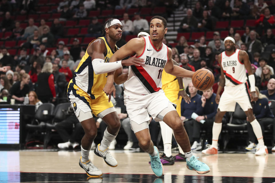 Portland Trail Blazers guard Malcolm Brogdon (11) drives to the basket as Indiana Pacers guard Buddy Hield defends during the first half of an NBA basketball game Friday, Jan. 19, 2024, in Portland, Ore. (AP Photo/Amanda Loman)