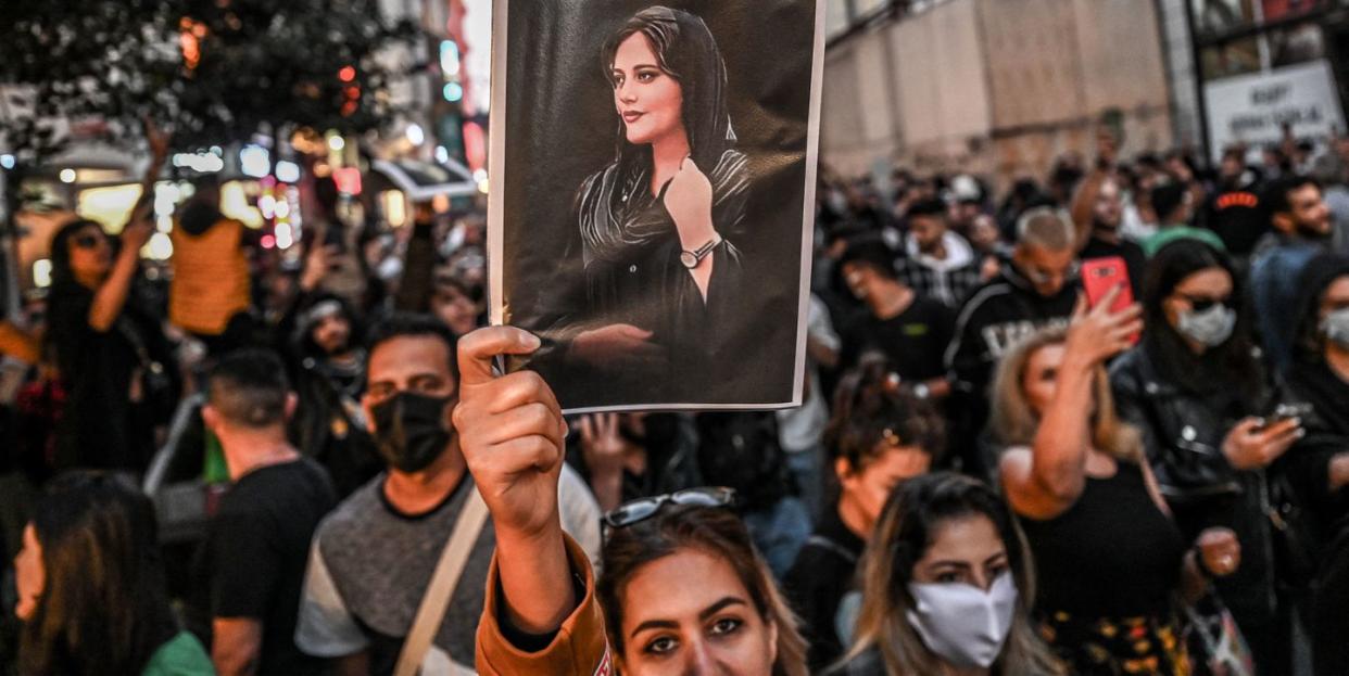 topshot   a protester holds a portrait of mahsa amini  during a demonstration in support of amini, a young iranian woman who died after being arrested in tehran by the islamic republics morality police, on istiklal avenue in istanbul on september 20, 2022   amini, 22, was on a visit with her family to the iranian capital when she was detained on september 13 by the police unit responsible for enforcing irans strict dress code for women, including the wearing of the headscarf in public she was declared dead on september 16 by state television after having spent three days in a coma photo by ozan kose  afp photo by ozan koseafp via getty images