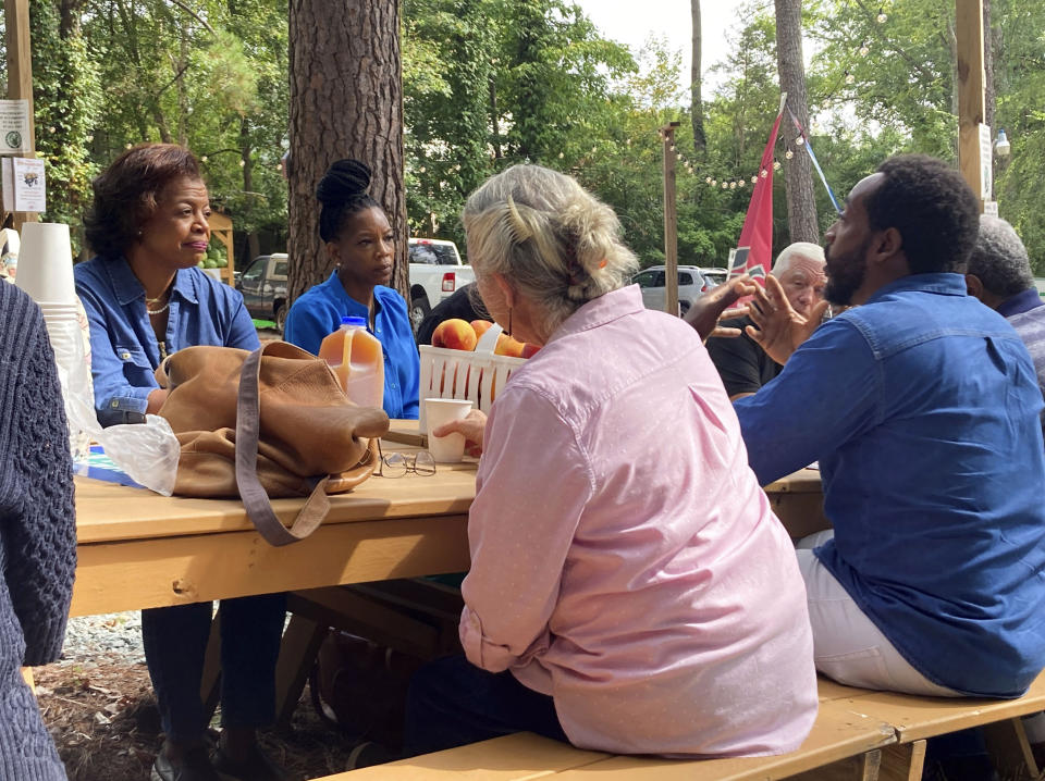 Democratic North Carolina Senate candidate Cheri Beasley, left, meets with farmers at Perkins Orchard produce stand Sept. 7, 2022, in Durham, N.C. Beasley, a former chief justice of the state Supreme Court, is trying to attract more support from voting blocs that have leaned Republican in recent years in the state. (AP Photo/Gary D. Robertson)