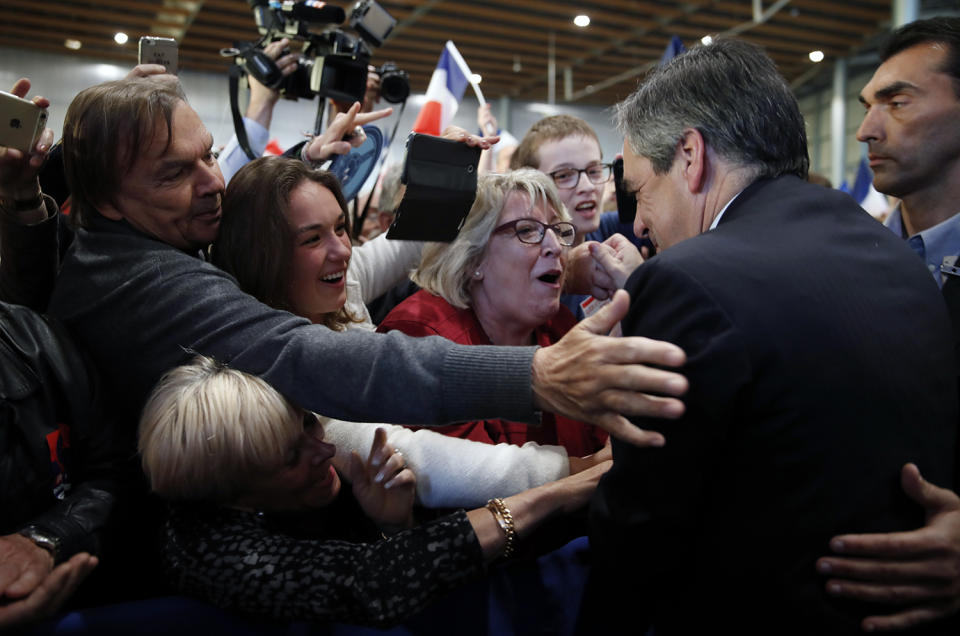 Francois Fillon is greeted by supporters as he arrives to attend a campaign rally in Lille