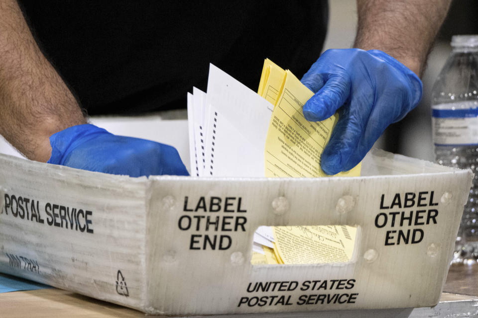 FILE - In this Jan. 5, 2021 file photo, Fulton County Georgia elections workers process absentee ballots for the Senate runoff election in Atlanta. Reports from an independent monitor who observed election operations in Georgia's most populous county during the 2020 election cycle detail tense encounters with party election monitors. (AP Photo/Ben Gray, File)