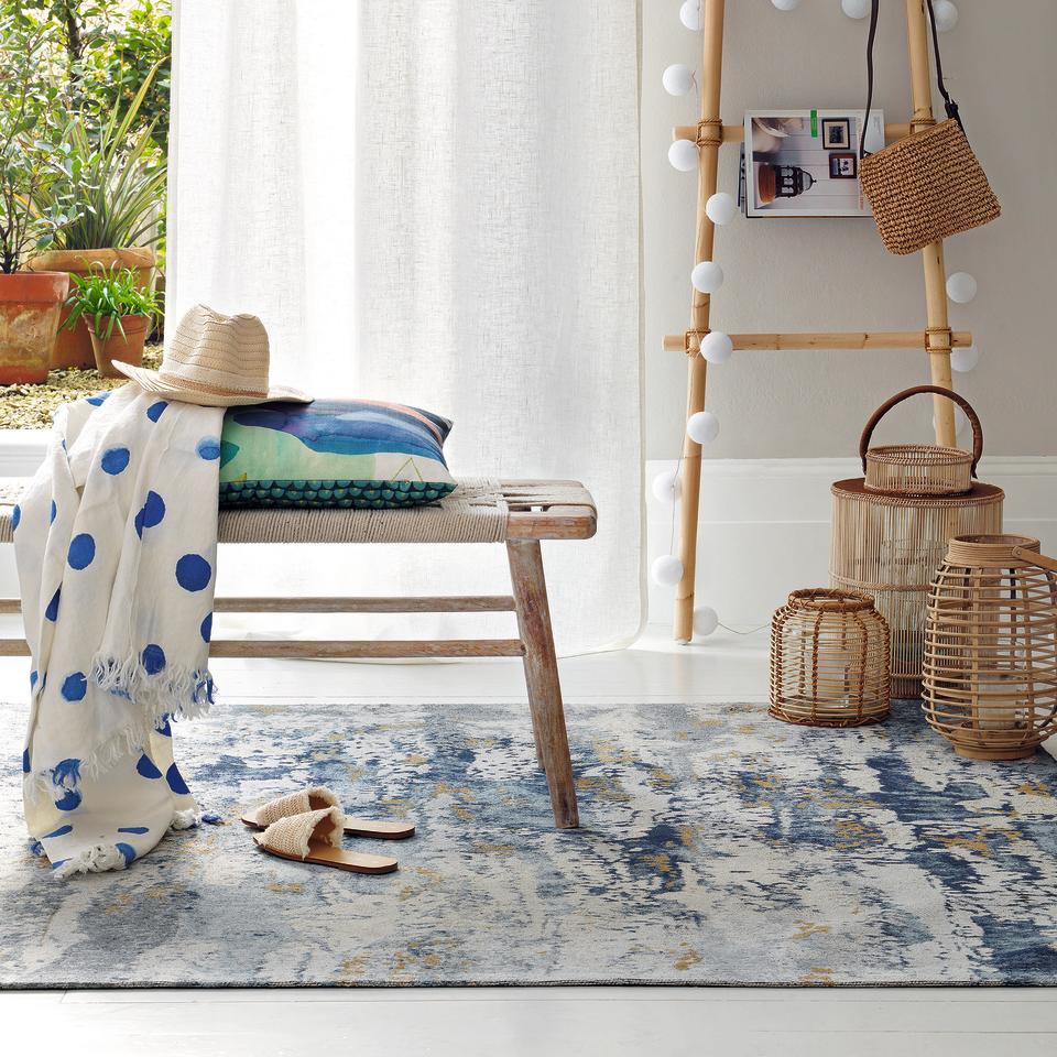 Living room with blue and white flat weave rug.