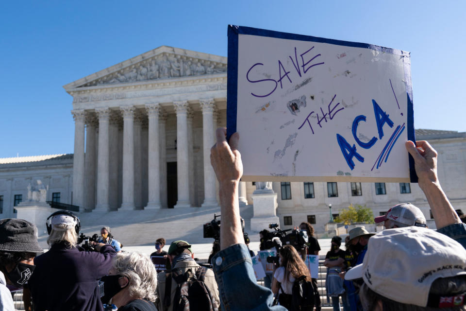A demonstrator holds a sign in front of the U.S. Supreme Court as arguments are heard about the Affordable Care Act Tuesday, Nov. 10, 2020.