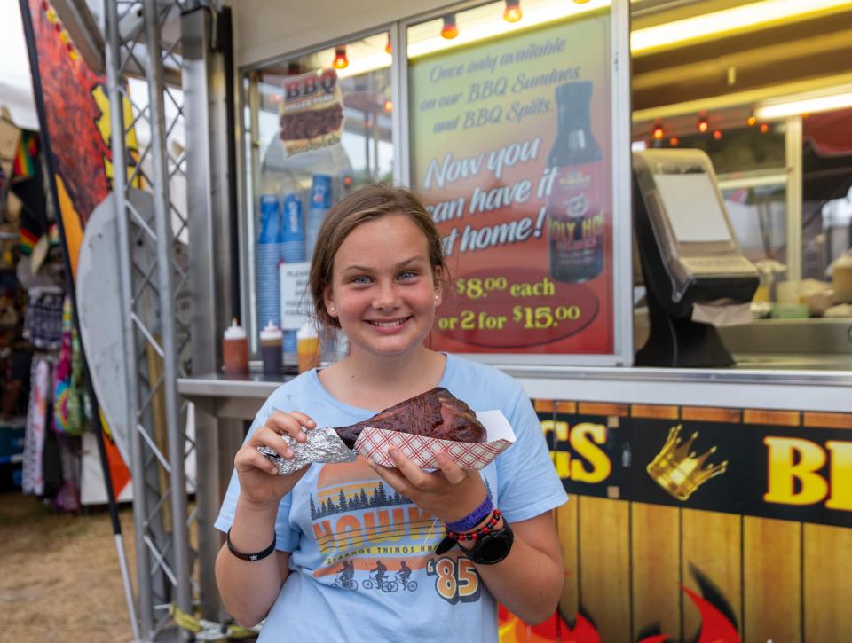 Daisy Talbot, 11, poses with a turkey leg Monday at Porky’s Pork Palace at the Barnstable County Fair in East Falmouth. Talbot has been coming to the fair every year and it was her first time having a turkey leg.