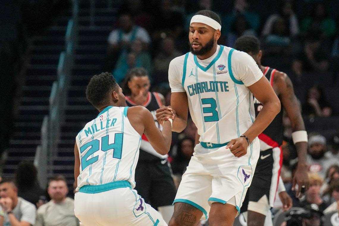 Apr 3, 2024; Charlotte, North Carolina, USA; Charlotte Hornets Marques Bolden helps forward Brandon Miller (24) to his feet after a foul during the second quarter against the Portland Trail Blazers at Spectrum Center.