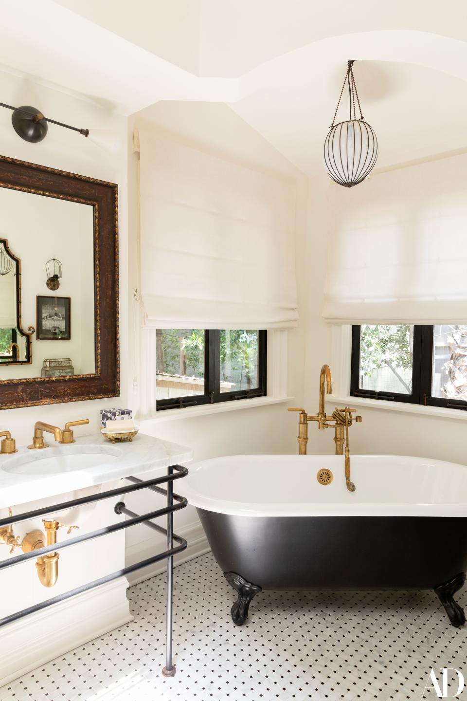 The master bathroom is classic, thanks to the details—which include brass fixtures and smart tiles. In one corner is a picture of Steve McQueen, bathing with his first of three wives, Niele Adams. Stamos shares: “She came to a party and I asked her to sign it,” Stamos recalls. “It says something like, ‘You’re more handsome than he was.’”