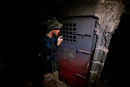 A member of Iraqi security forces inspects a building that was used as a prison by Islamic State militants in Hammam al-Ali, south of Mosul, during an operation to attack Islamic State militants in Mosul, Iraq November 7, 2016. REUTERS/Thaier Al-Sudani