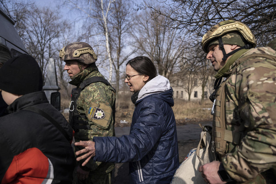 Olga Shulga and her son Myroslav, board a van during an evacuation by Ukrainian police, in Avdiivka, Ukraine, Tuesday, March 7, 2023. For months, authorities have been urging civilians in areas near the fighting in eastern Ukraine to evacuate to safer parts of the country. But while many have heeded the call, others -– including families with children -– have steadfastly refused.(AP Photo/Evgeniy Maloletka)