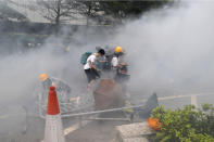 Protesters react to a cloud of tear gas near the Legislative Council in Hong Kong, Wednesday, June 12, 2019. Thousands of protesters blocked entry to Hong Kong's government headquarters Wednesday, delaying a legislative session on a proposed extradition bill that has become a lightning rod for concerns over greater Chinese control and erosion of civil liberties in the semiautonomous territory. (AP Photo/Kin Cheung)