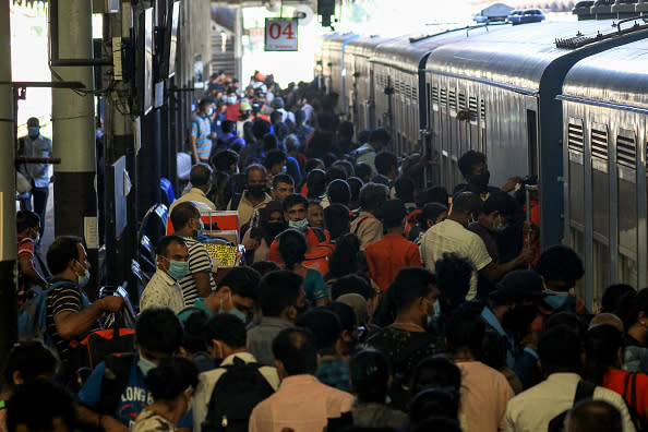 Sri Lankan commuters wearing face masks get in to the train at the Fort Railway Station, Colombo, Sri Lanka. 