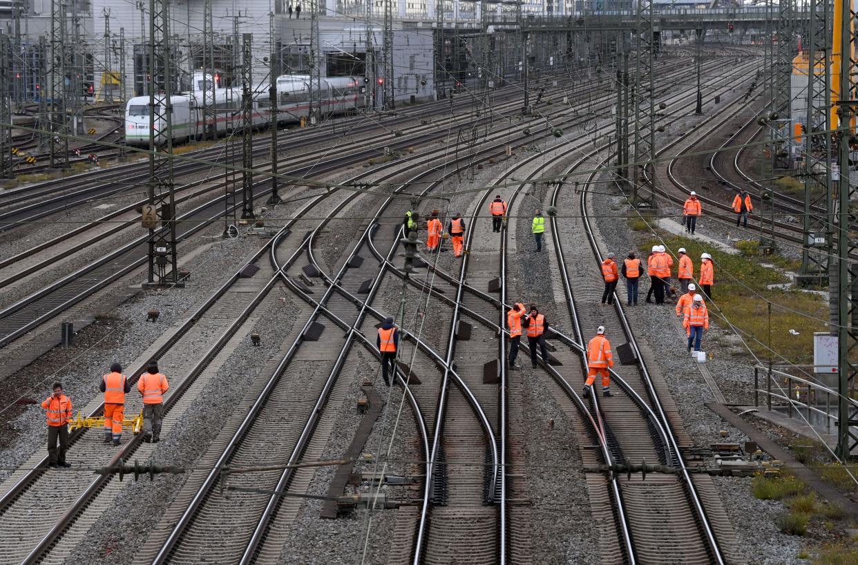 Workers check the rails as tracks are blocked after a bomb explosion close to the main railway station in Munich.