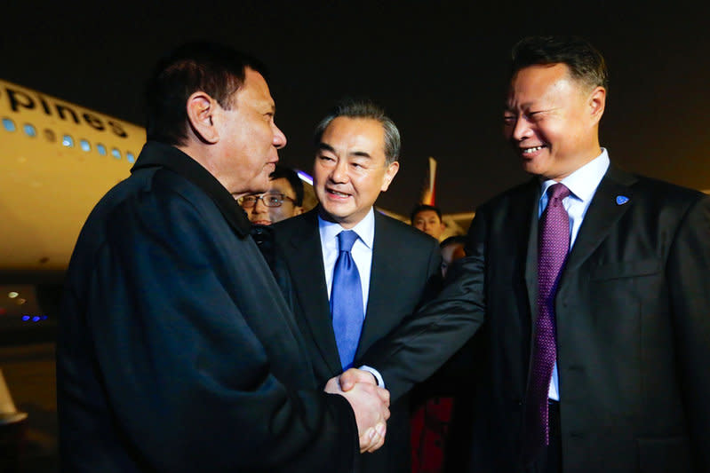 President of the Philippines Rodrigo Duterte (L) shakes hands with Chinese ambassador to the Philippines Zhao Jianhua (R), as Chinese Foreign Minister Wang Yi (C) looks on, at airport in Beijing, China, October 18, 2016. CNS Photo via REUTERS