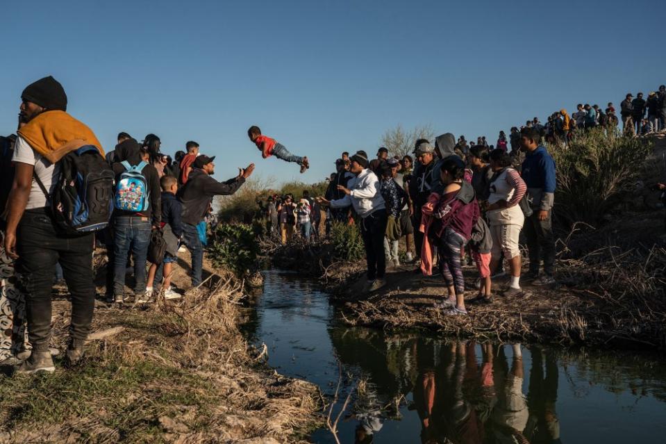A child passes over a narrow stretch of the Rio Grande at the U.S. border with Mexico on March 29. Driven partly by a surge of Venezuelans seeking asylum, a record number of people migrated from South and Central America to the U.S., with arrivals reaching 2.5 million in the federal fiscal year that ended in October.<span class="copyright">Go Nakamura—The New York Times/Redux</span>