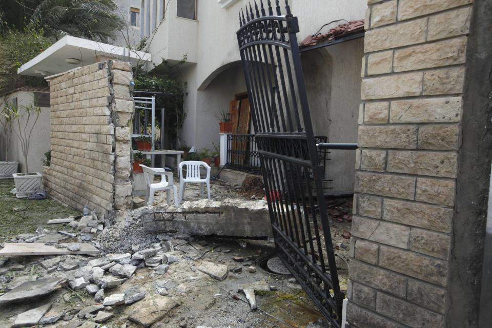 A general view of the damage caused by a bomb blast is seen at the gate of the Iranian ambassador's residence in Tripoli