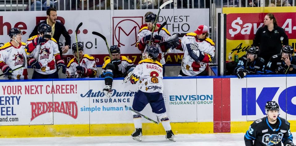Rivermen winger Tyler Barrow drives Quad City center Connor Fries over the boards and into the Peoria bench during a 3-0 Rivermen victory at Carver Arena on Friday, Nov. 25, 2022.