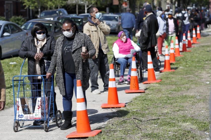 In this Tuesday, May 12, 2020, photo, residents from all walks of life line up for a food giveaway sponsored by the Greater Chicago Food Depository in the Auburn Gresham neighborhood of Chicago. Across the country, food insecurity is adding to the anxiety of millions of people, according to a new survey that finds 37 percent of unemployed Americans ran out of food in the past month, while 46 percent worried that they would. The nationwide unemployment rate on Friday was 14.7 percent, the highest since the Great Depression.(AP Photo/Charles Rex Arbogast)