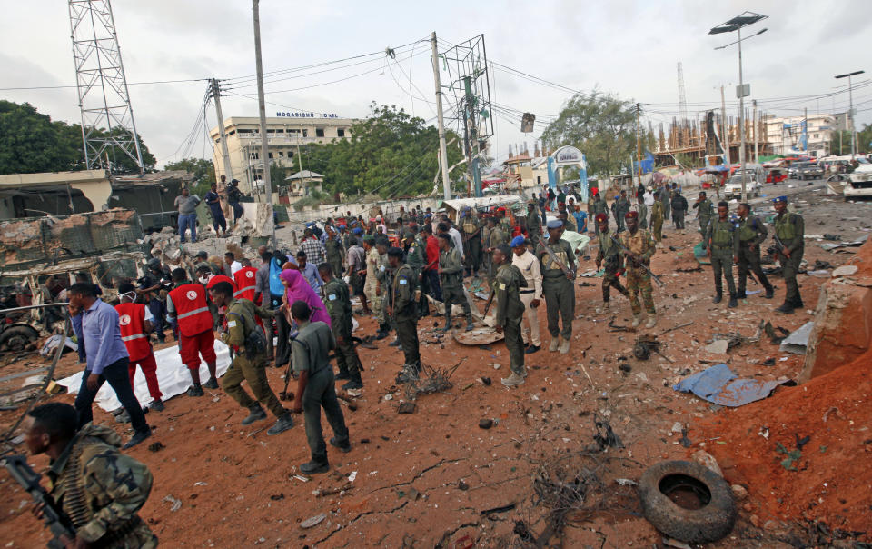 Security forces attend the scene of a bomb blast near the Sahafi hotel in the capital Mogadishu, Somalia, Friday, Nov. 9, 2018. Three car bombs by Islamic extremists exploded outside the hotel, which is located across the street from the police Criminal Investigations Department, killing at least 10 people according to police. (AP Photo/Farah Abdi Warsameh)