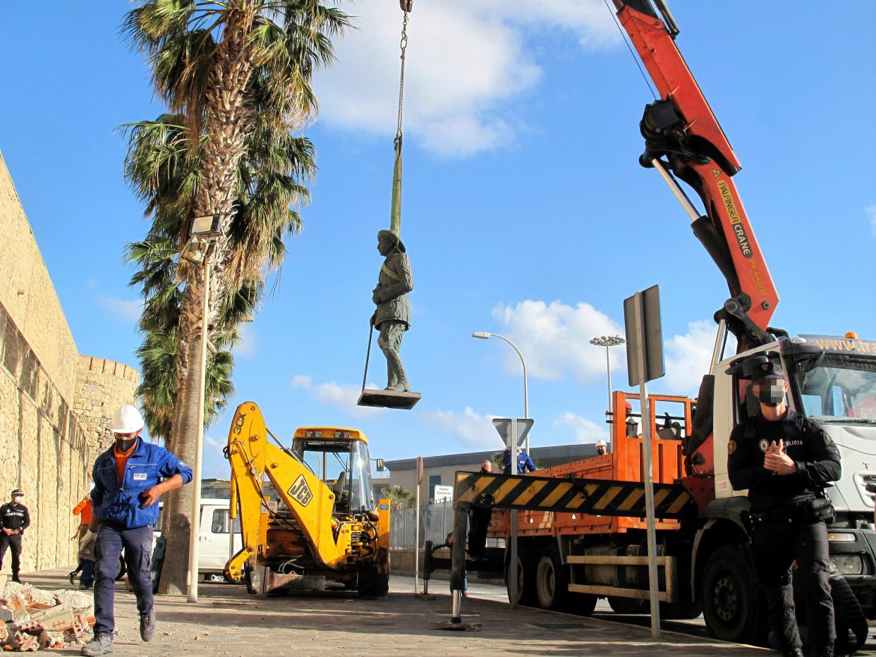 A crane removes the statue of Franco located in front of the wall of Melilla’s old town (Europa Press via Getty Images)