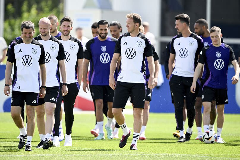 Germany's head coach Julian Nagelsmann, front centre, players and staff members walk on the pitch during a training session Herzogenaurach, June 13, 2024