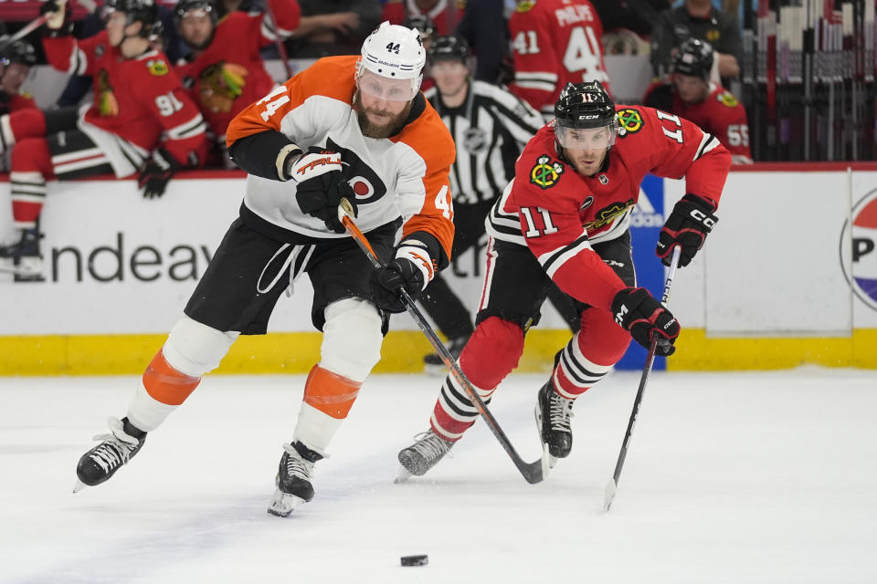 Philadelphia Flyers center Sean Couturier, left, and Chicago Blackhawks right wing Taylor Raddysh chase the puck during the first period of an NHL hockey game Wednesday, Feb. 21, 2024, in Chicago. (AP Photo/Erin Hooley)