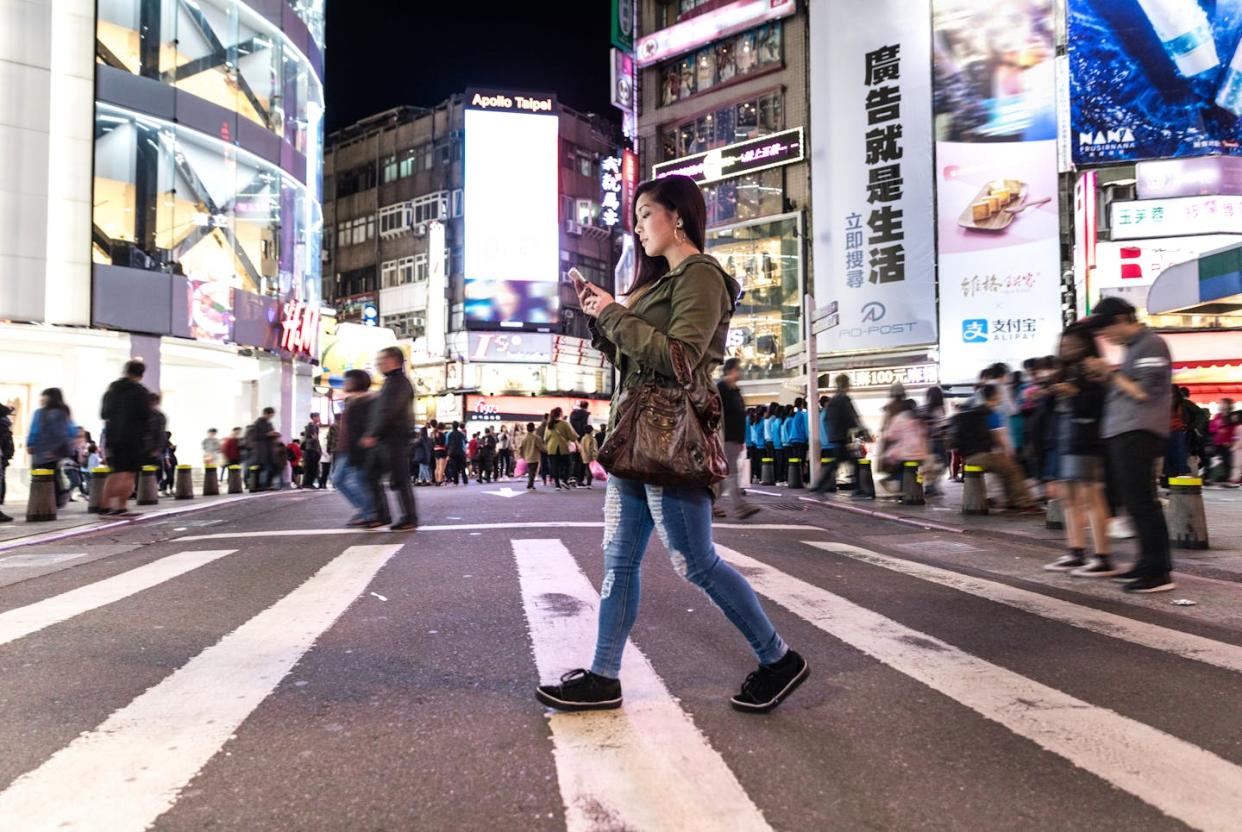 A woman checks her mobile phone in downtown Taipei in Taiwan. <a href="https://www.gettyimages.com/detail/photo/asian-woman-at-night-in-ximen-district-downtown-royalty-free-image/934696244?phrase=taiwan+social+media&adppopup=true" rel="nofollow noopener" target="_blank" data-ylk="slk:LeoPatrizi/Getty Images;elm:context_link;itc:0;sec:content-canvas" class="link ">LeoPatrizi/Getty Images</a>